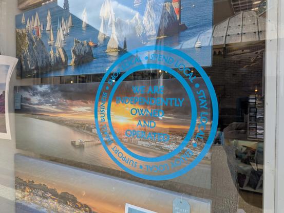 A blue window sticker urging people to shop and support local. It states that we are independently owned and operated.