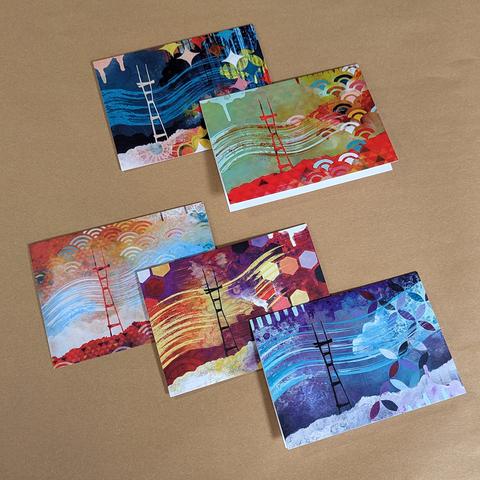 5 note cards with prints of Sutro tower paintings on the front, arrayed on a kraft paper backdrop. Each one is different. They are blank inside.