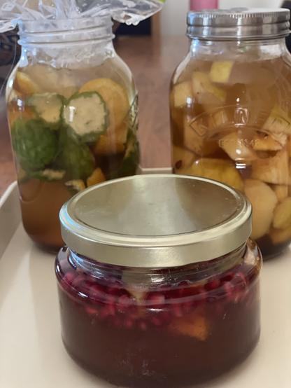 Quince and pomegranate honey (front); citrus peel vinegar (left), quince vinegar (right).