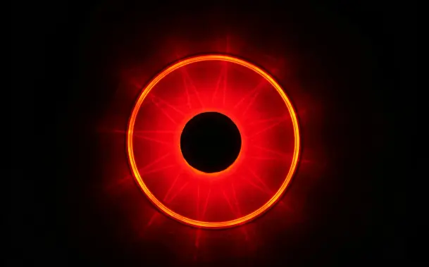 Image of a red circle of light that resembles a human iris over a black background.