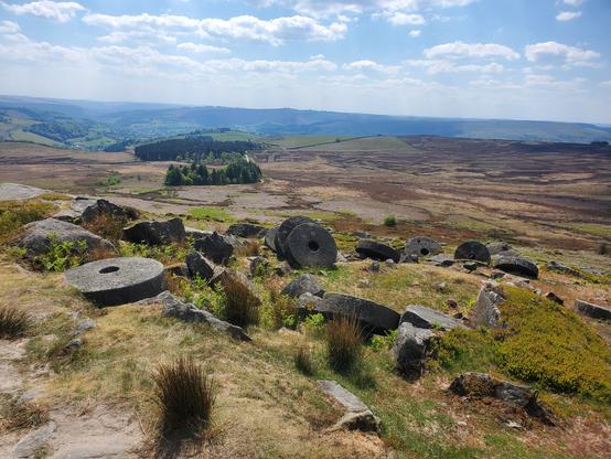 Round stone millstones scattered across the landscape