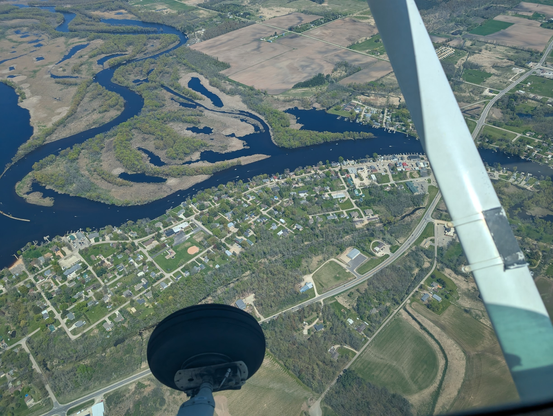 A river as seen from the air. It is full of boats traveling and enjoying the nice weekend weather.