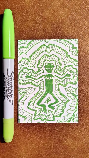 Marker drawing of a doodled abstract Kermit the Frog floating in midair with waves of doodled lines and patterns surrounding him. The drawing is signed with my "RV" signature glyph and dated 5-10-25. The double-tipped green Sharpie marker used to draw the image rest on the table above the card.