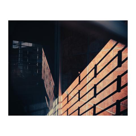 The reflection of a light through a rolling gate on a shop window