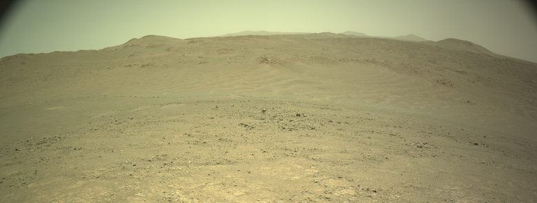 An ochre toned panorama capturing a Martian landscape. This is a stitching of two images captured by the rover's navigation camera.