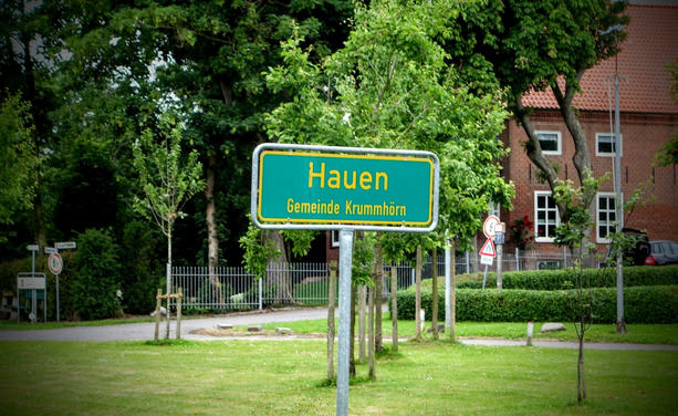 Ein Ortsschild am Wegesrand ist beschriftet mit "Hauen - Gemeinde Krummhörn"