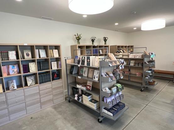 interior of building, viewed from entrance toward rear

shelves with books along back wall

small wheeled island of shelves perpendicular to that

design details:
https://www.emilydickinsonmuseum.org/carriage-house-reconstruction/