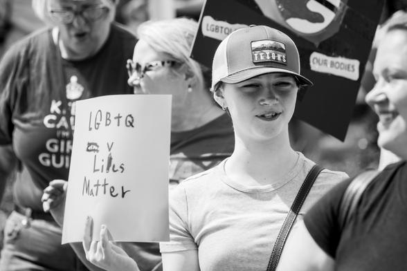 A young lady at the "Hands Off" protests with a hand made sign on which she misspelled a word and then corrected it as best she could.