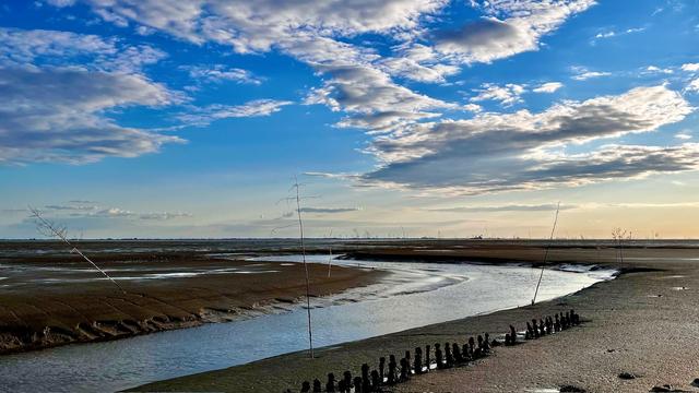 Water-filled fairway at the cutter harbor surrounded by mudflats at low tide.
