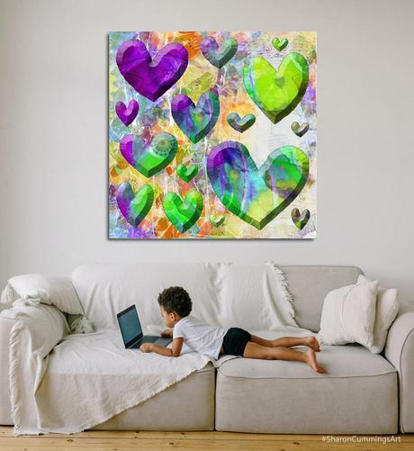 Colorful purple and green hearts onba colorful background over a sofa with a little boy on a laptop.  Art by Sharon Cummings.