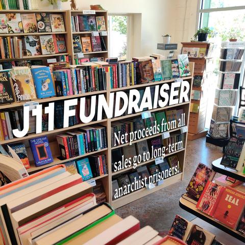 A photo of the bookshelves at Firestorm on a sunny day. Text is superimposed over the shelves that reads "J11 Fundraiser: Net proceeds from all sales go to long-term political prisoners!"