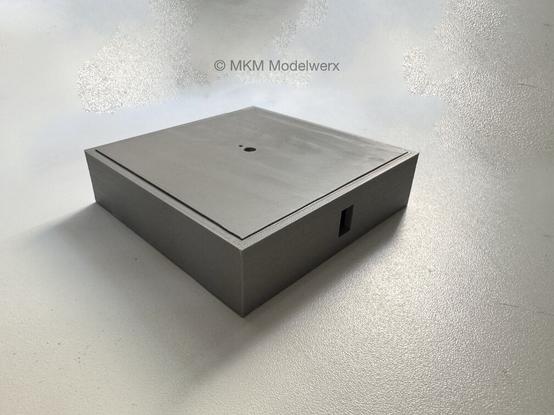 Grey square printed base for displaying models.