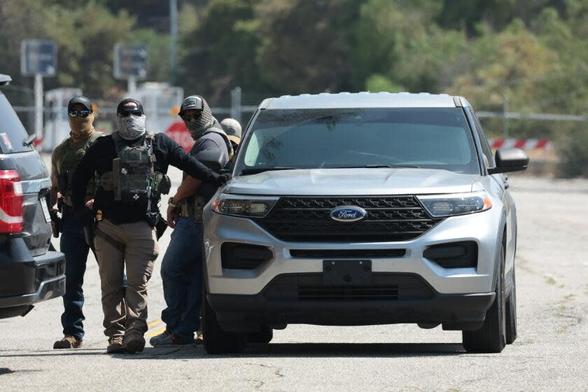 Federal agents stage outside Gate E of Dodger Stadium on June 19. (Myung J. Chun / Los Angeles Times)