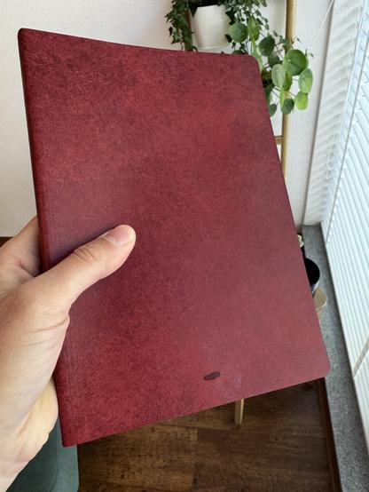 A dark red A5 sized journal with a small stain located at the bottom. I don’t know what the stain is…