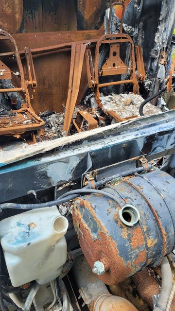 Driver and passenger seat in a burned, abandoned dump truck's cab