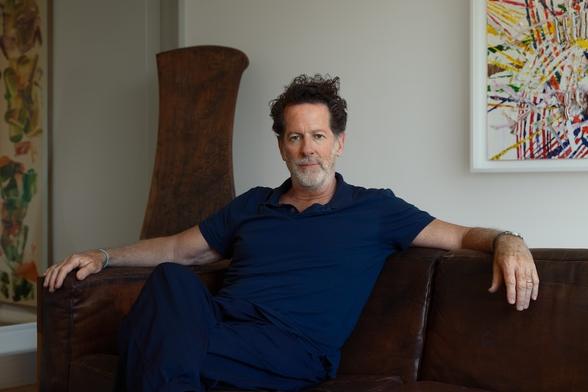Portrait of a man with curly hair and a salt and pepper beard.