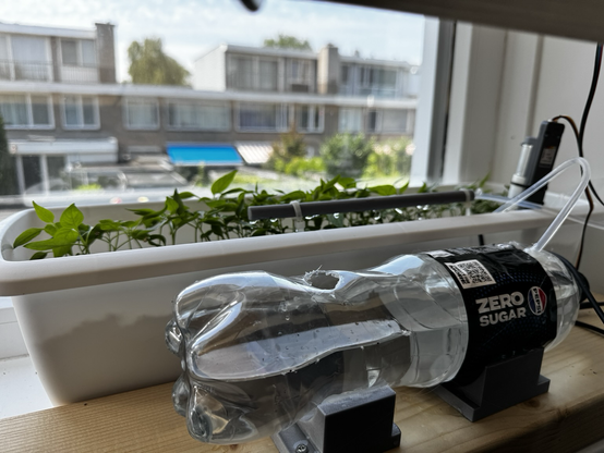 An automatic watering system for my peppers featuring a Pepsi bottle reservoir
