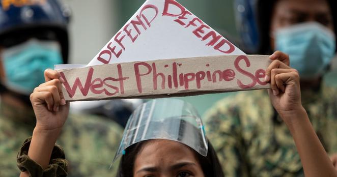 An activist holds a prop with the words “defend West Philippine Sea” during a protest outside the Chinese Consulate in Manila’s financial district on the anniversary of an international arbitral court ruling invalidating Beijing’s historical claims over the waters of the South China Sea, in Makati City, Philippines, July 12, 2021.