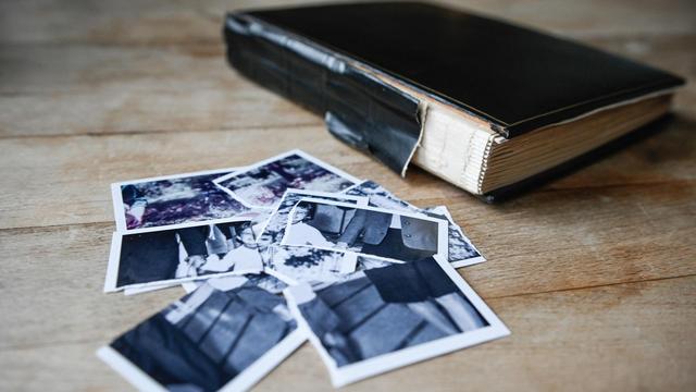 Zerrissene Kinderbilder liegen auf einem kleinen Haufen neben einem Fotoalbum auf einem Tisch am 27. Januar 2022 in Bonn. Zerrissene Kinderbilder liegen auf einem kleinen Haufen neben einem Fotoalbum auf einem Tisch am 27. Januar 2022 in Bonn.
