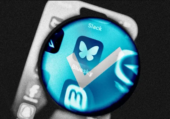 A close-up view of smartphone app icons, featuring the Bluesky logo with a checkmark, set against a blue-tinted background.