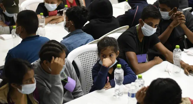 In a May 2022 file photo, unaccompanied migrant minors deported from Mexico wait to eat a meal at a shelter in Quetzaltenango, Guatemala. They were rescued and deported while trying to reach the United States.