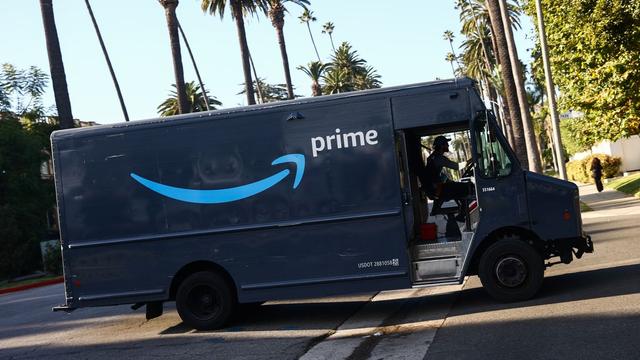 An Amazon Prime truck drives by palm trees in Los Angeles. An Amazon Prime truck drives by palm trees in Los Angeles.