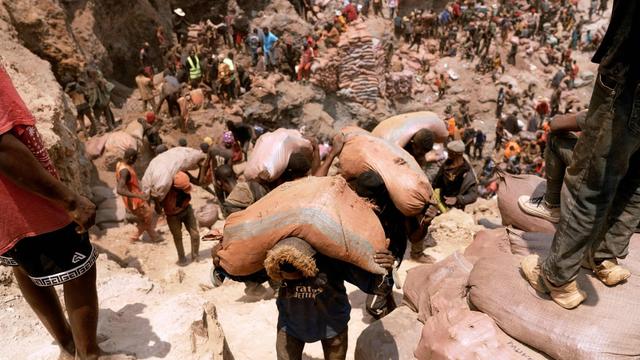 Miners carry sacks of ore near Kolwezi. | Junior Kannah/AFP via Getty Images