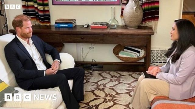 Duke of Sussex sat in a suit sat on a sofa opposite Nada Tawfik