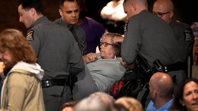 A woman is carried out by law enforcement at a town hall held by U.S. Rep. Mike Lawler, R-N.Y., Sunday, May 4, 2025, in Somers, N.Y. (AP Photo/Jessica Hill)