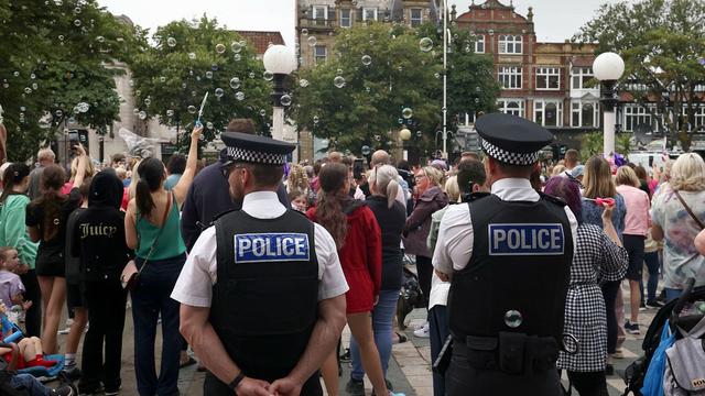 Police officers watch members of the public outside the Town Hall in Southport, 5 August, 2024 | Copyright AP Photo