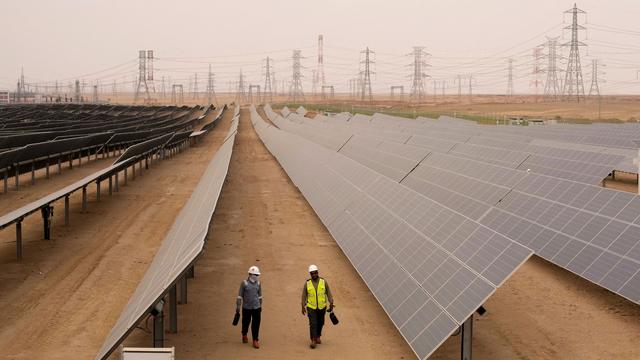 Engineers walk next to solar panels at Benban Solar Park in Aswan. | Copyright AP Photo