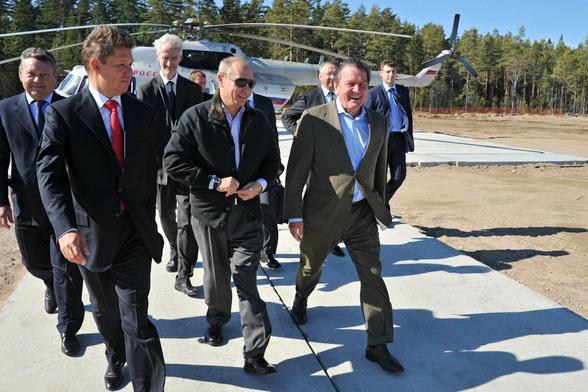 Putin und Schröder laufen lachend mit Begleitern vor einem Helikopter Putin und Schröder laufen lachend mit Begleitern vor einem Helikopter