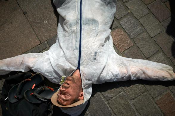 Eine Person liegt in einem weißen Schutzanzug auf dem Boden Eine Person liegt in einem weißen Schutzanzug auf dem Boden
