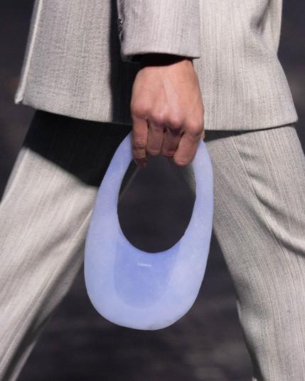 A model holds a small purse made of aerogel, a softly transparent blue color and adorned with the logo of the Coperni fashion brand. A model holds a small purse made of aerogel, a softly transparent blue color and adorned with the logo of the Coperni fashion brand.