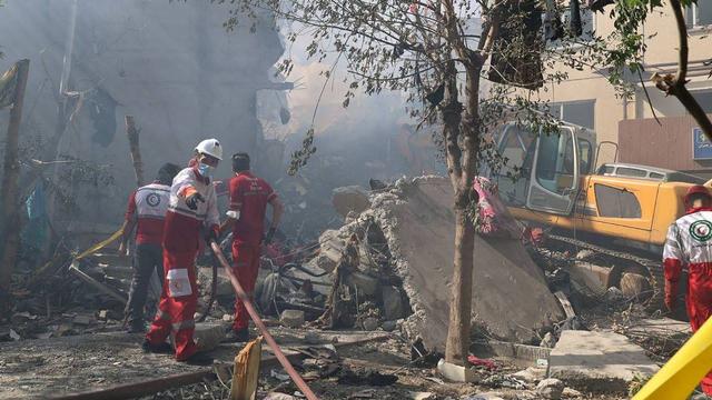 Cette photo, publiée par le Croissant-Rouge iranien le 14 juin 2025, montre des volontaires de l'ONG dans un quartier de Téhéran (Iran) touché par une frappe israélienne.