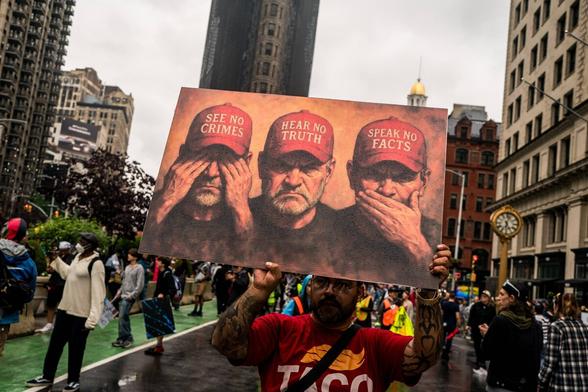 Ein Transparent auf einer Protestkundgebung am Samstag in New York: ?Sieh keine Verbrechen, höre keine Wahrheit, sprich keine Fakten aus!?