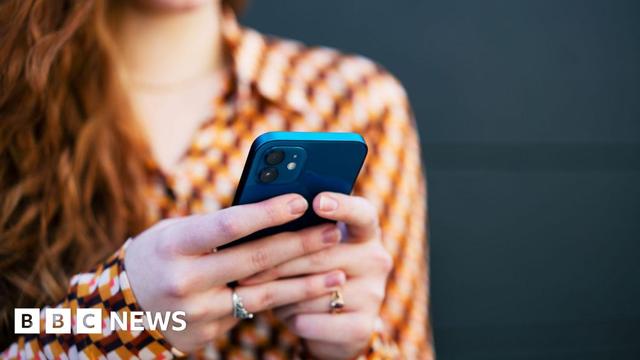 A person's hands using a phone