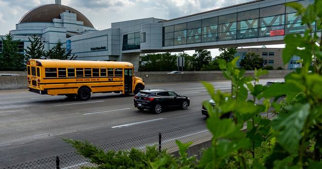 Vehicles pass by the St. Louis Science Center and a sign, upper right, indicating Thursday's air quality is unhealthy for sensitive groups on Wednesday, May 31, 2023, near Forest Park.