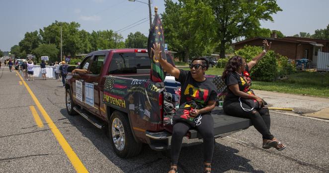 State Rep. Chantelle Nickson-Clark, D-St. Louis, St. Louis County Council Chair Shalonda Webb ride in a pickup truck decorated for Juneteenth on June 19, 2024 in St. Louis.