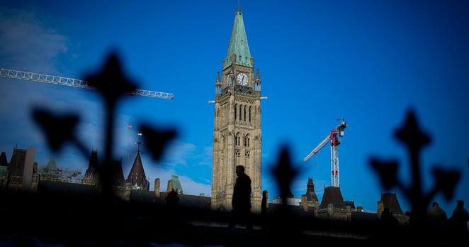 A person makes their way past the Peace Tower on Parliament Hill in Ottawa on Tuesday, Feb. 13, 2024. THE CANADIAN PRESS/Sean Kilpatrick