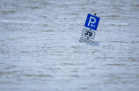 Ein Parkplatzschild für Wohnmobile steht im Hochwasser
