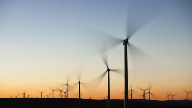 Wind turbines in front of a sunrise, with their blades blurred due to their motion. Wind turbines in front of a sunrise, with their blades blurred due to their motion.