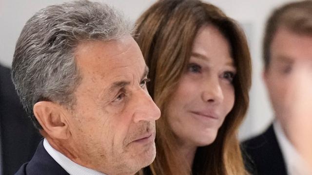 Former French President Nicolas Sarkozy, next to his wife Carla Bruni Sarkozy, speaks after a Paris court sentenced him to 5 years in prison and said he'll be incarcerated even if he appeals, after finding him guilty in his trial for alleged illegal campaign financing by Libya, Thursday, Sept. 25, 2025 in Paris. (AP Photo/Michel Euler)