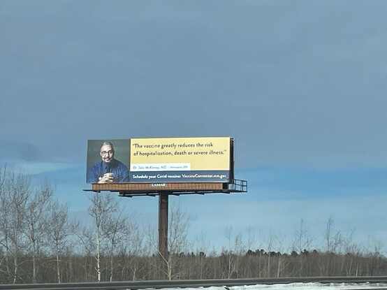 Billboard featuring Zeke McKinney with the quote, "The vaccine greatly reduces the risk of hospitalization, death, or severe illness."