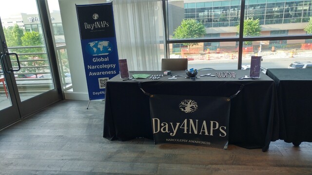 Narcolepsy awareness table with giveaway items.