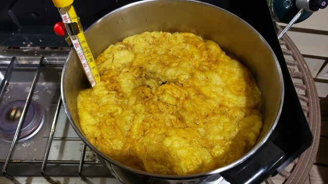 Yellow colored wool cooling in a pot of mulberry leaf dye.
