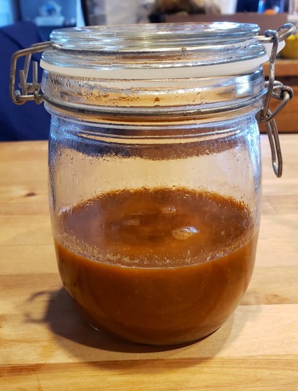 A flip-top jar half-full of fermented hot sauce.