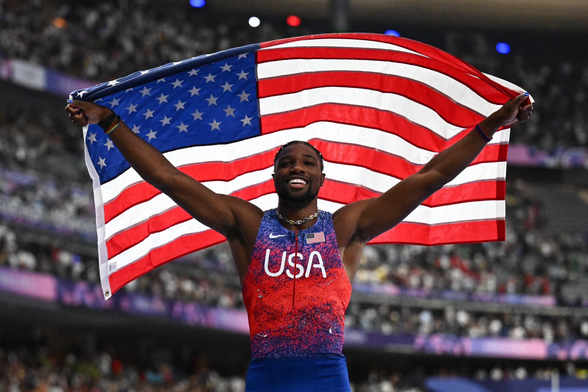 Noah Lyles holding US flag