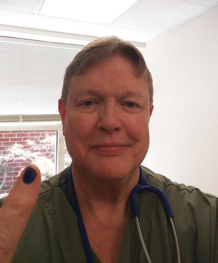 Doctor in scrubs with a pinky fingernail painted blue. 