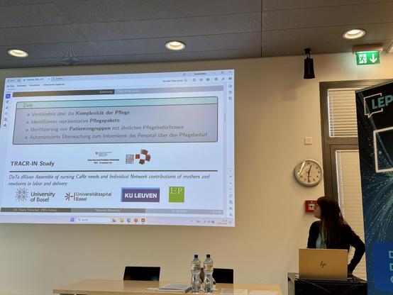 Foto von Diana Trutschel vor einer PPT-Folie zum TRACR-Projekt. 